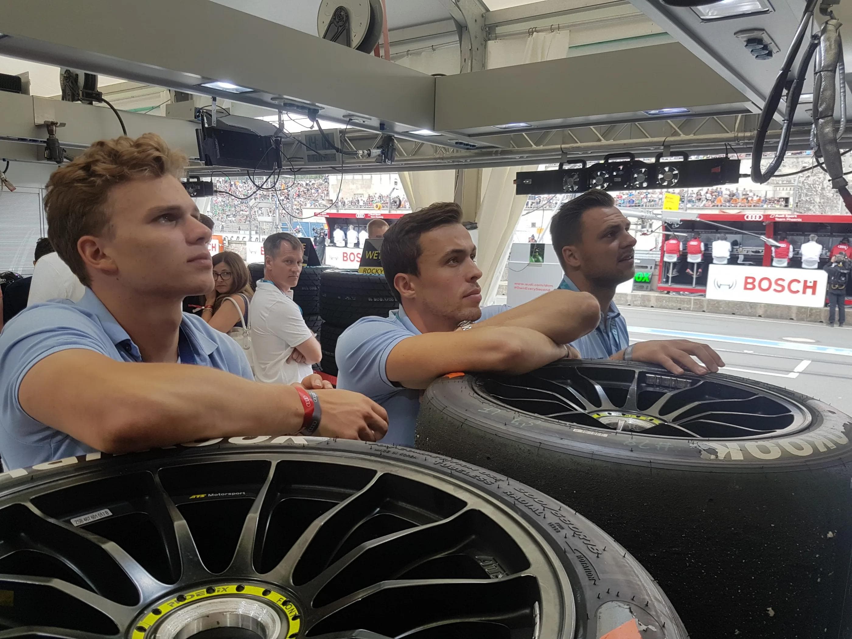 Tim Wohlgemuth, Fabio Wagner und David Elsner verfolgen das Rennen aus der Audi-Box.