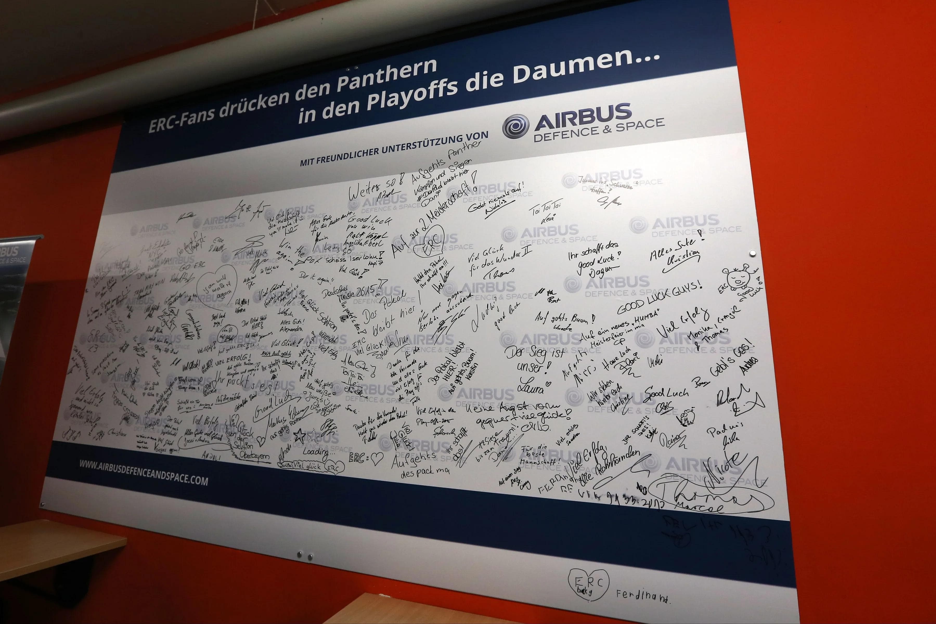 Im Rundlauf der Saturn Arena hat ERC-Partner Airbus eine weiße Wand angebracht, auf der die Fans ihre Grüße und Wünsche für die Panther hinterlassen können. Der Andrang war groß. Foto: Stefan Bösl / kbumm.de