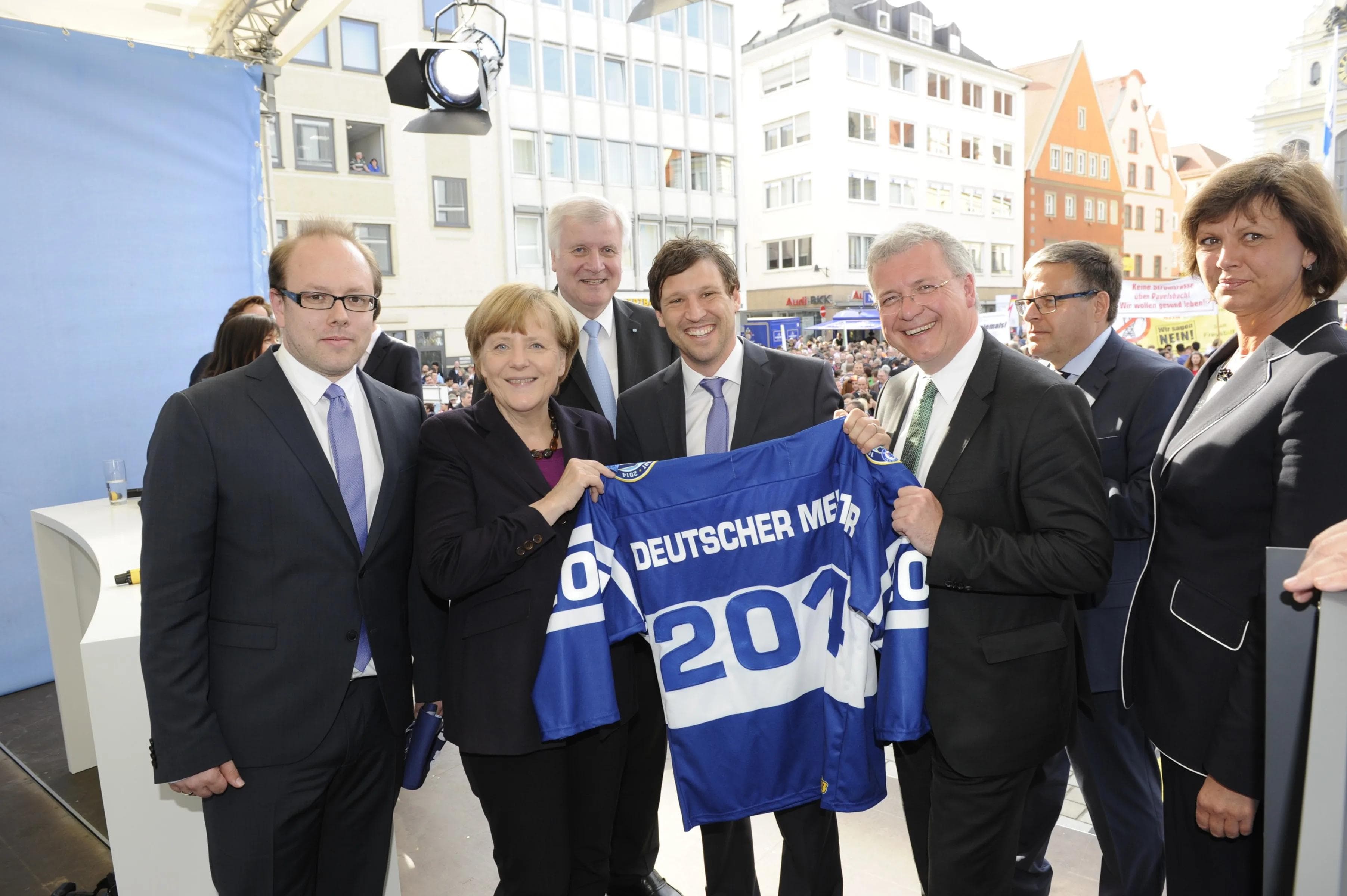ERC-Geschäftsführer Claus Gröbner überreicht Angela Merkel ein Meistertrikot (Foto: CSU)