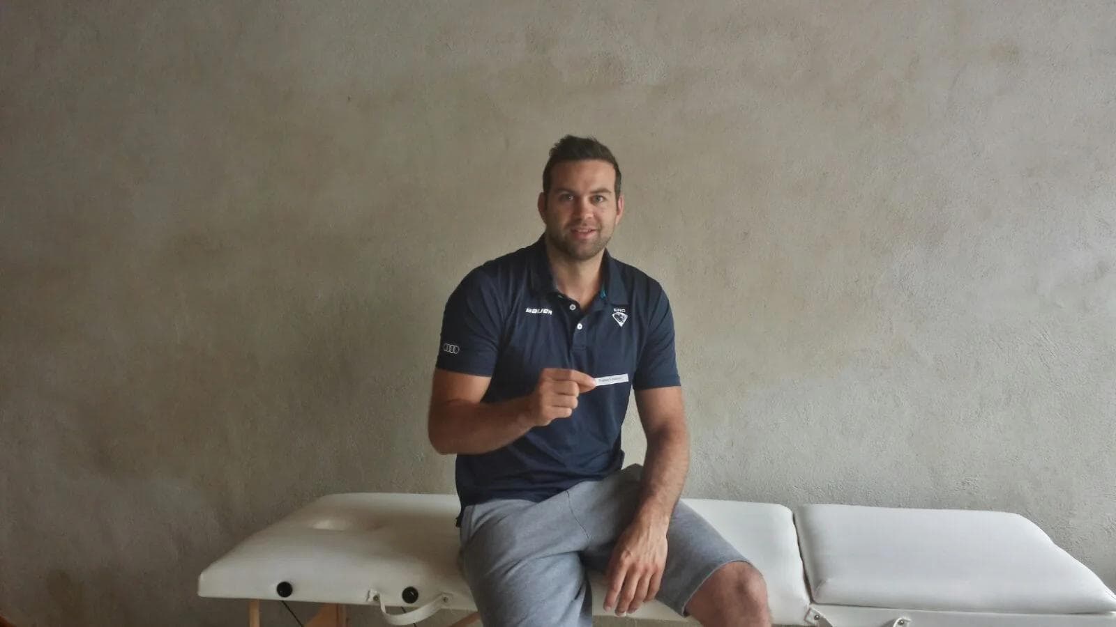 Dominik Gerzer mit dem Gewinner-Los auf der Massagematte.