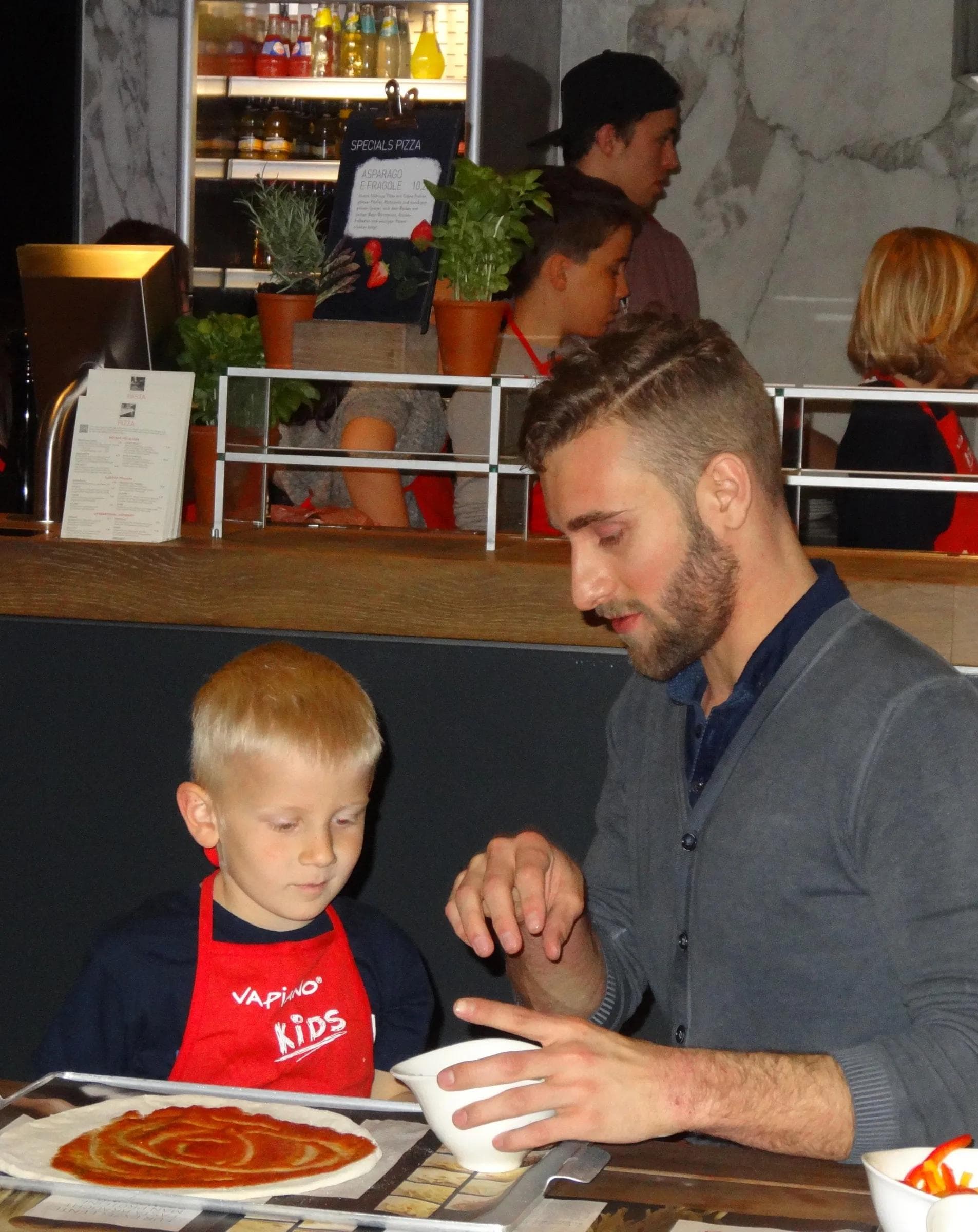 Stephan Kronthaler erkundigt sich bei seinem jungen Fan, was auf die Pizza drauf soll.