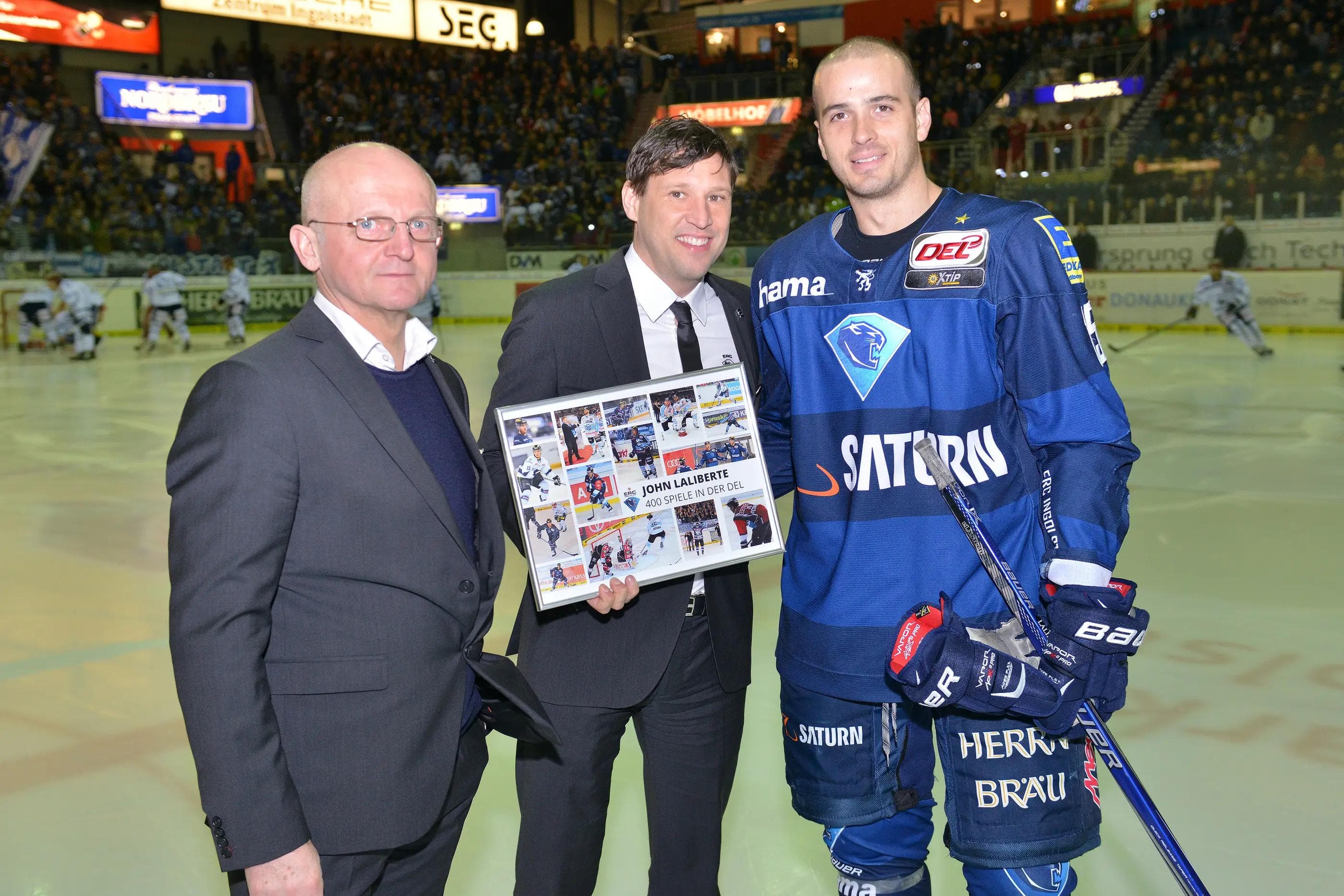 John Laliberte (rechts) nimmt die Glückwünsche von Geschäftsführer Claus Gröbner und Sportdirektor Jiri Ehrenberger entgegen. Foto: st-foto.de / Traub