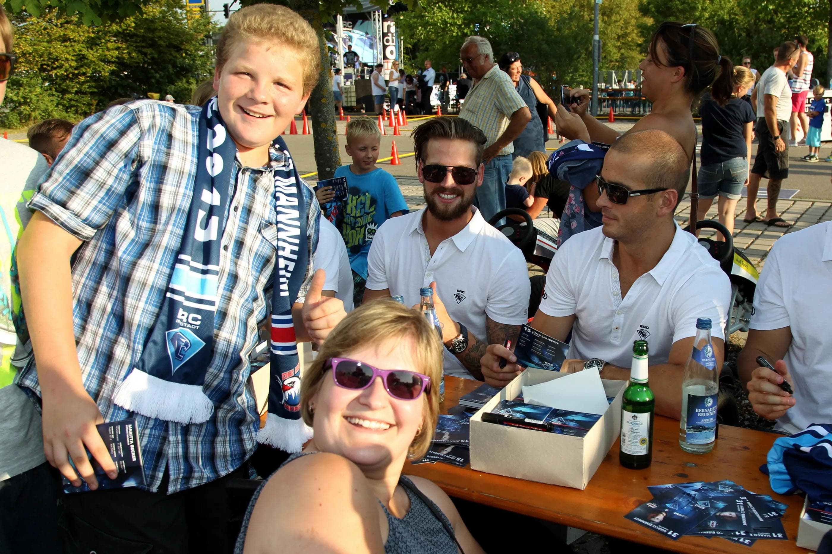 Timo Pielmeier (Zentrum) und John Laliberte freuen sich über das Foto mit diesen beiden Fans. Foto: Jürgen Meyer